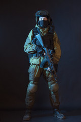 The man in the image of a member of the special forces division with assault rifle in blue light. Russian police special force - Special Rapid Response Unit or SOBR (Spetsnaz).