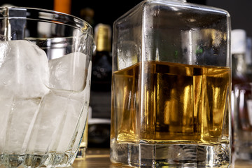 Whisky bottle beside ice bucket. On the pub