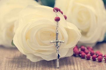 Catholic rosary and white roses