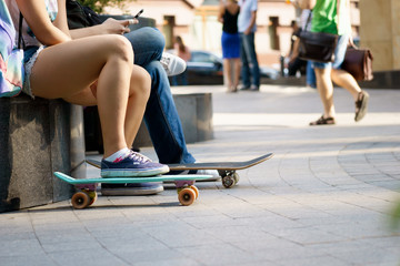 Fototapeta premium Young person sitting with skateboards and resting on summer day