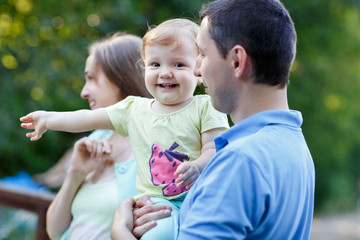 Happy family with little daughter in summer park