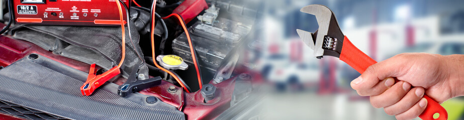 Hands of car mechanic with wrench in garage.