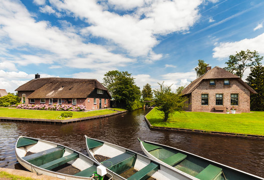 Small Dutch canal boats in front of old houses in Giethoorn