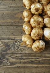 Aerial view of garlic bulbs arranged on a rustic wooden kitchen counter background