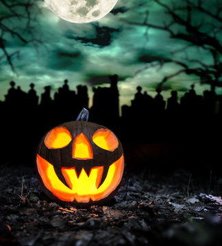 Scary halloween pumpkin with graveyard