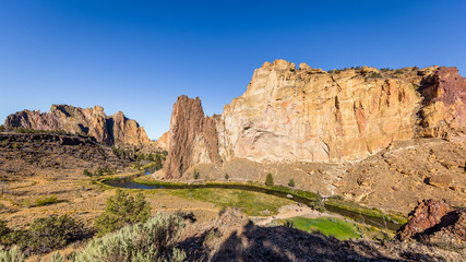 Fototapeta na wymiar The river is flowing among the rocks. Colorful Canyon. Amazing landscape of yellow sharp cliffs. Smith Rock state park, Oregon