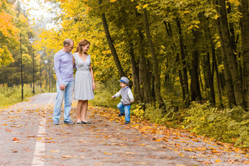 Fototapeta premium Young family walking in the park an autumn day