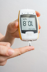 Diabetic patient is monitoring blood glucose level with glucometer. Diabetes concept.