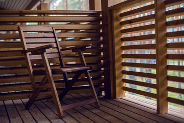 lone wooden chair on the balcony of wood with baffles