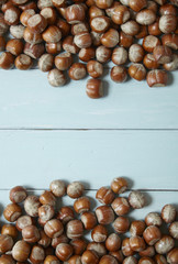 Whole hazel nuts arranged on a painted wooden background to form a page border