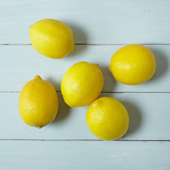 Aerial view of lemons arranged on a blue wooden table background
