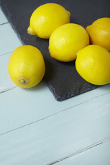 Lemons arranged on a slate and blue wooden background forming a page border
