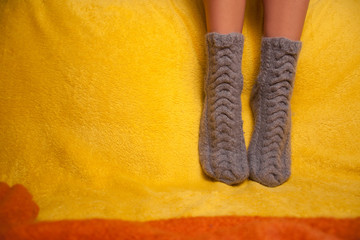 Girl in knitted socks on the sofa