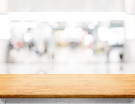 Empty wooden table and blurred shoppping mall bokeh light backgr