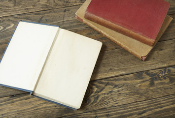 An open blank book on an old wooden desk top background 