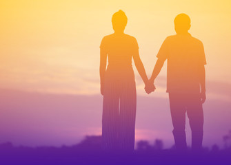 Young couple  Hand in hand  at sunset on the Mountain