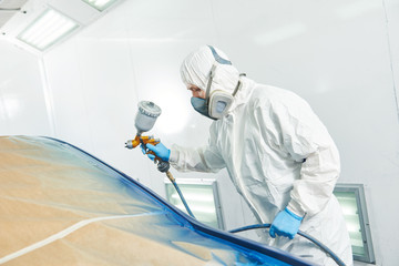 repairman painter in chamber painting automobile car bumper