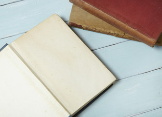 An open old story books on a blue wooden desk top background