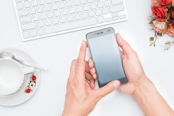 Business person working on smart phone with white workspace