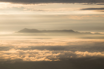 Mountain layer in morning sun ray and winter fog.