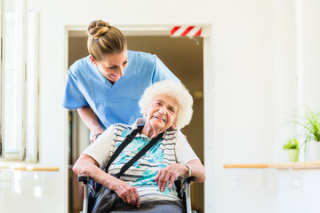 Altenpflegerin mit Patientin im Rollstuhl