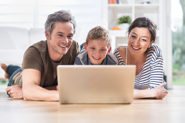 At home, cheerful family sharing a funny video on a laptop