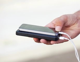 Hand holding mobile phone and batter pack