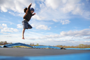 Young Child Jumping on Outdoor Family Trampoline