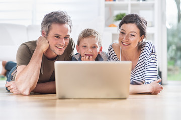 At home, cheerful family sharing a funny video on a laptop