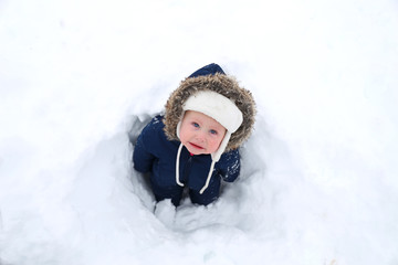 Fototapeta na wymiar Cold Baby in Winter Snowsuit in Snow