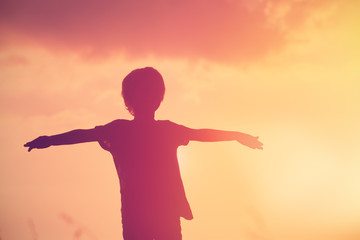 Fototapeta na wymiar Silhouette of little boy play at sunset sky