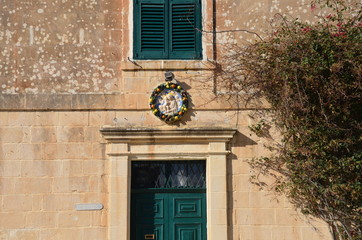 Fototapeta na wymiar Old house in Malta with green windows