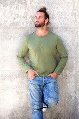 Man with beard leaning against wall