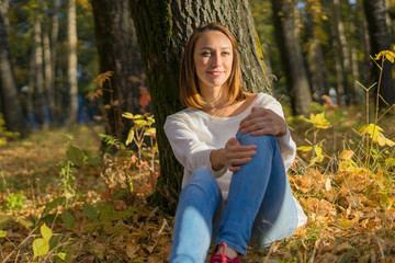 Girl sitting under a tree in the forest