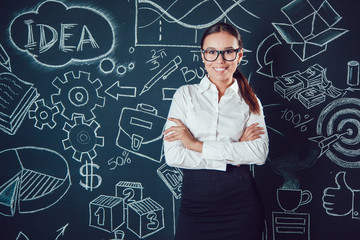 Portrait of a asian business woman in glasses standing on background with pictures