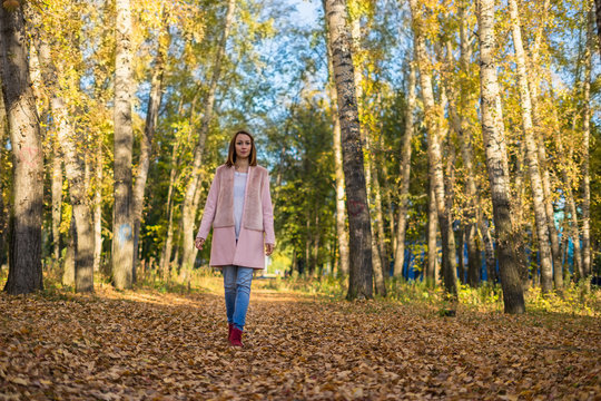 Young girl walking in the autumn forest.