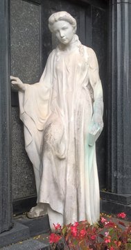 trauernde Frau in weissem Gewand und einer Bibel in ihrer Hand