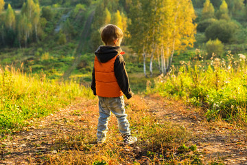 The boy standing at the edge of the forest