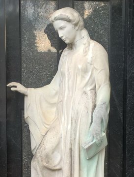 trauernde Frau in weissem Gewand und einer Bibel in ihrer Hand