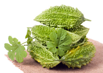 heap of bitter melon or momordica with leaves isolated on white background