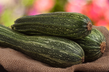 green zucchini or courgettes on sackcloth with a blurred background