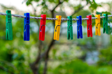 Fototapeta na wymiar Colored clothespins for linen hanging on a rope