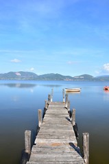 Wood pier and little boat on a lake