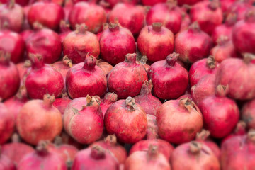 A lot of fresh ripe pomegranates on the market, nature fruit blurred background
