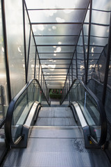 illuminated corridor between glass walls going to escalator entr
