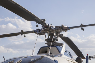 blades of a helicopter standing on land on a helipad
