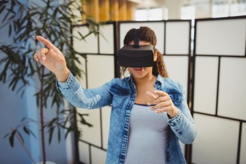Businesswoman pointing while using virtual reality headset 