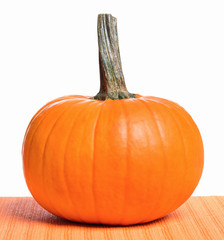 Fresh orange pumpkin on table, isolated on white background. Studio shot of a nice ornamental autumn pumpkin for Halloween.