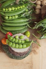 Fresh green peas pod on wood background.