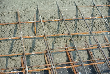 The wet concrete is poured on a steel reinforcement to form strong floor slabs.